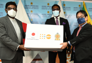 在スリランカ日本大使館の水越英明大使（右）とUNFPAスリランカ事務所代表のクンレ・アデニイ（中央）が、同国の保健大臣（左）にセクシュアル・リプロダクティブ・ヘルス（SRH）を守るために必要な医薬品と物資を手渡しました。